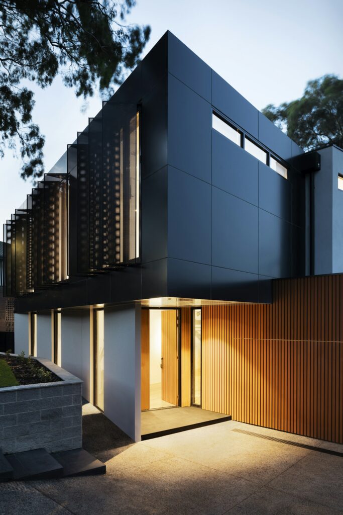 Modern Cerberus Citadel home with European tilt-turn windows glowing at dusk