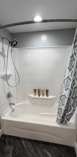 Bathroom before remodel: old tub surround with shower curtain