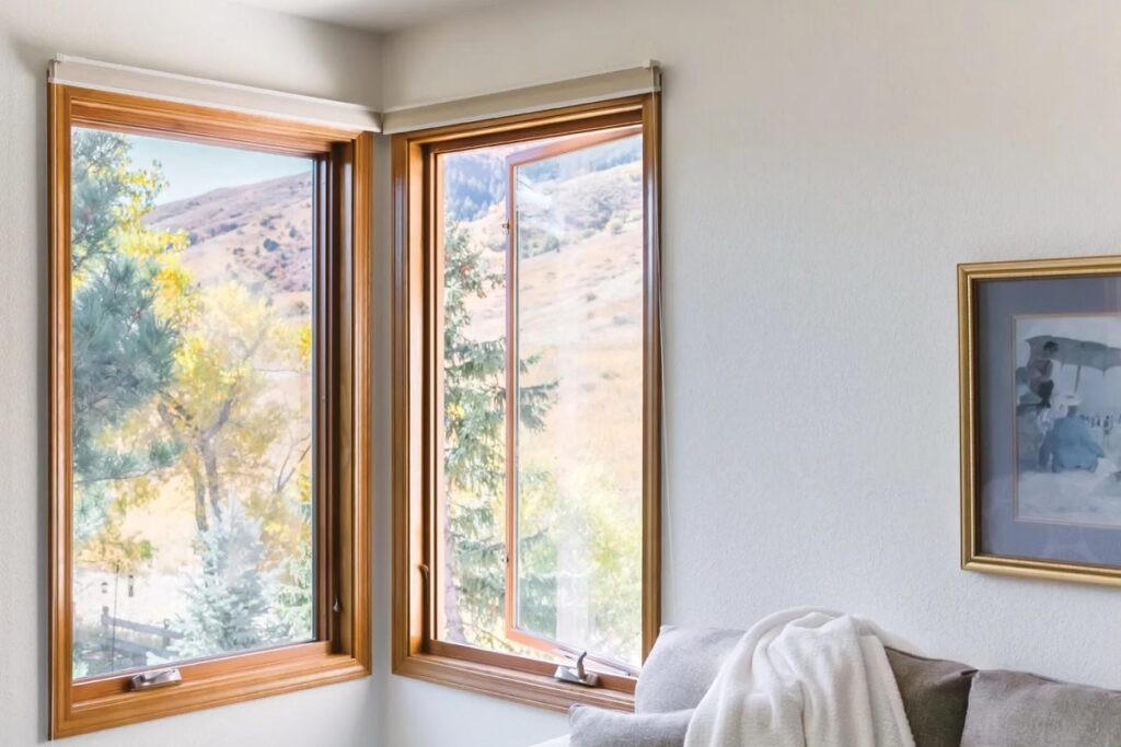 Corner casement windows with one sash cranked open to a mountain view
