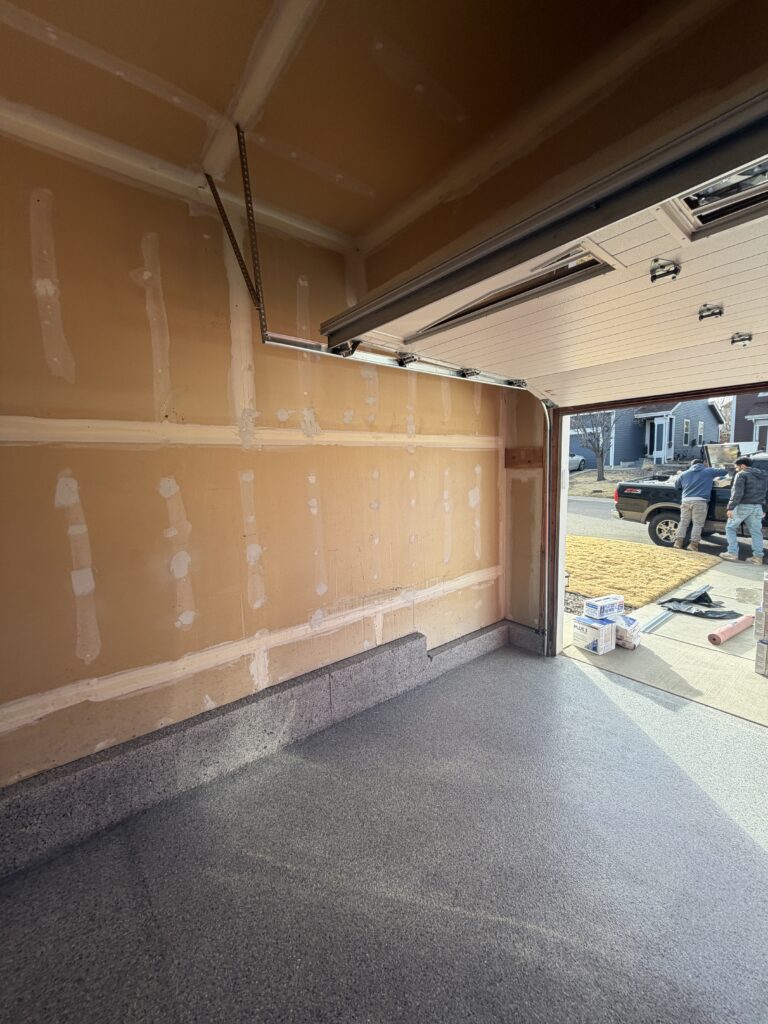 Garage walls before painting — bare taped and mudded drywall